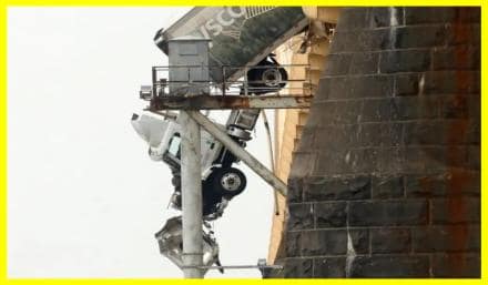 Driver rescued from truck hanging on bridge